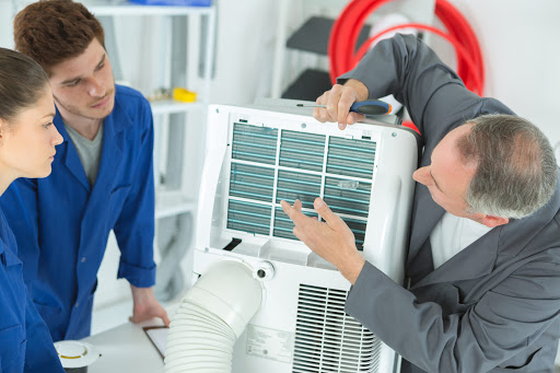 Our senior technician giving a lesson in HVAC services to junior technicians at a client’s house in Jefferson Parish