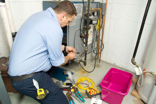 Keefe's technician fixing furnace in New Orleans' home.