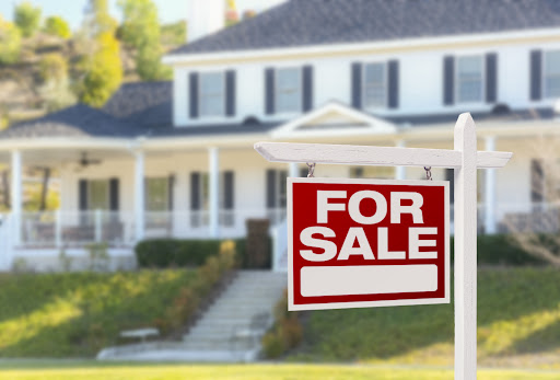 A home with a "For Sale" placed in the front yard.