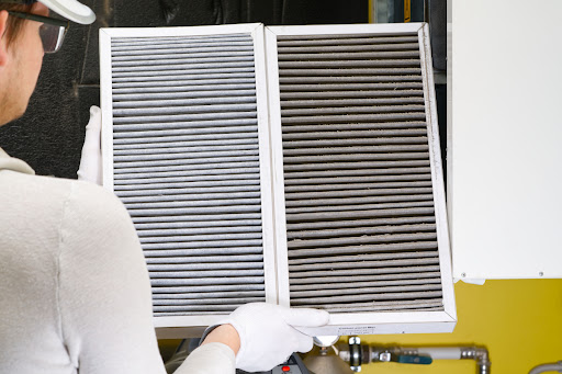 A person holding an HVAC filter.